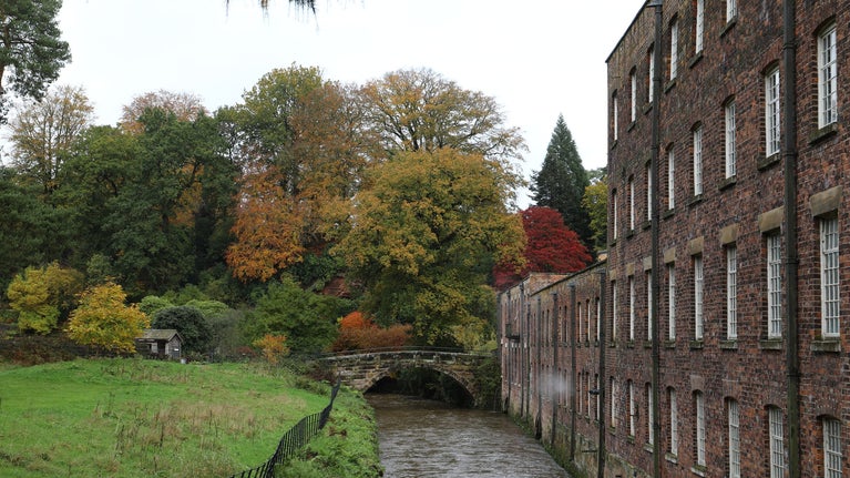 A view of the River Bollin and mill at Quarry Bank in Autumn